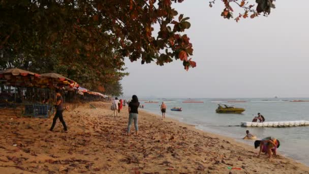 Pattaya, Thajsko - 4 února 2017: Lidé sedí na pláži před západem slunce. Turisté jsou spočívající na pobřeží — Stock video