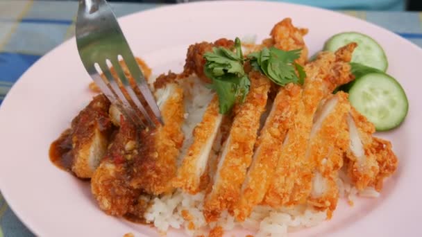 A man eats a fork with Thai food. Rice with pea pods and fried crispy chicken on breading — Stock Video