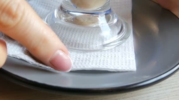 Vrouw draait een schotel en een glas met een latte in een café, op de schotel ligt een cookie in de vorm van koffiebonen — Stockvideo