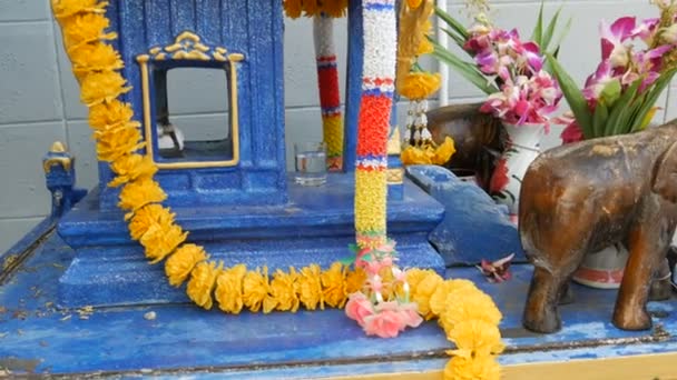 Vackert inredda traditionella buddhistiska altaret i trädgården i Thailand, med blommor och olika symboliska figurer — Stockvideo