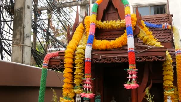 Magnifiquement décoré autel bouddhiste traditionnel dans le jardin en Thaïlande, avec des fleurs et diverses figures symboliques — Video