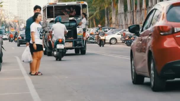 2017年12月14日, 泰国芭堤雅: 一条街道的景色。有棕榈树的路堤, 在路上有汽车、出租车、小巴、motobikes 和街头小贩。 — 图库视频影像
