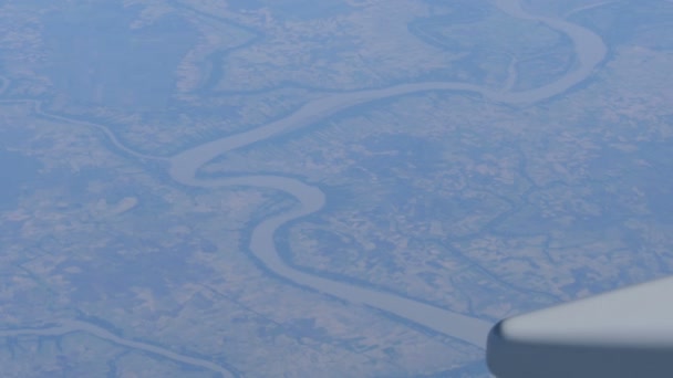Paesaggio dell'Asia. Belle catene montuose, fiumi tortuosi, prati verdi. Vista dall'alto da un aereo. Ala di un aeroplano sullo sfondo del paesaggio terrestre — Video Stock