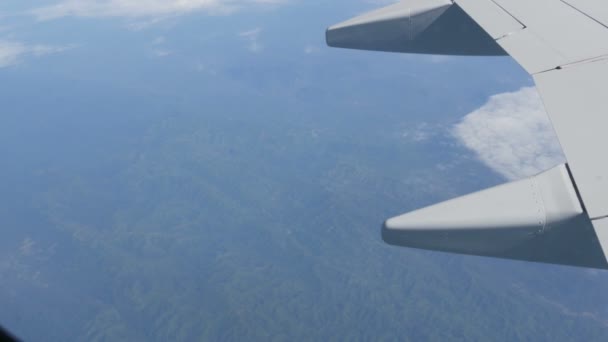Paesaggio dell'Asia. Belle catene montuose, fiumi tortuosi, prati verdi. Vista dall'alto da un aereo. Ala di un aeroplano sullo sfondo del paesaggio terrestre — Video Stock