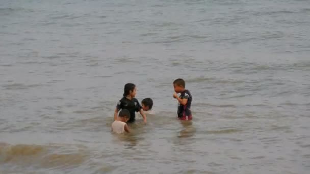 Pattaya, thailand, 14. Dezember 2017: kleine thailändische Kinder baden bei Sonnenuntergang im Südchinesischen Meer. Asiatische Kinder tummeln sich im Meerwasser — Stockvideo