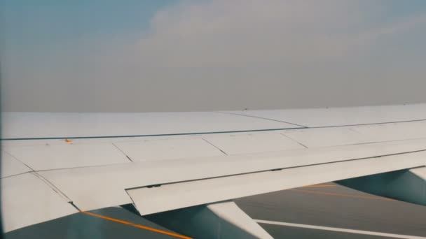 DUBAI, UAE - FEBRUAR 8, 2018: Flyet i lufthavnen er ved at blive klar til start passerer et væld af andre forskellige fly. Optagelse fra salonen – Stock-video