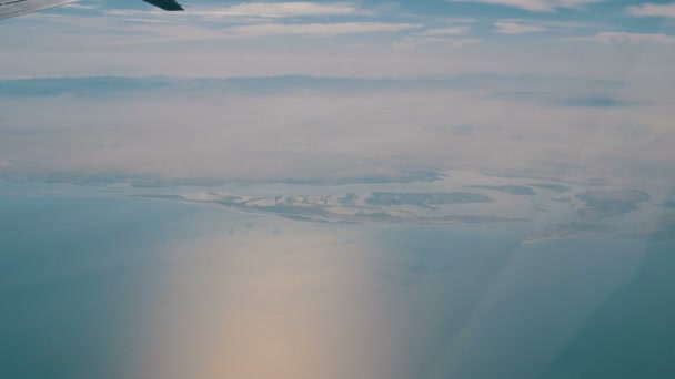 Αεροπλάνο που πετάει πάνω από την επιφάνεια του νερού. Η λίμνη είναι μια κορυφαία προβολή — Αρχείο Βίντεο