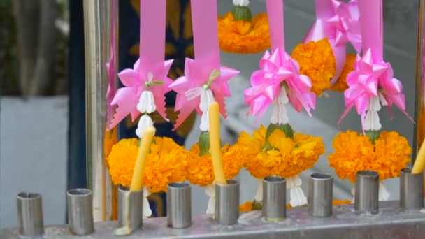 Віск, свічки та квіти поблизу традиційної буддійської вівтар в Таїланді — стокове відео