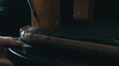 El bir gencin bir matkap aldı ve bir tahta sandalyede bacak bir delik delinir ve bir demir vida dövülmüş
