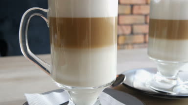 Şık kafe tablo şeffaf özel bardakta süt ve hava köpük ve siyah bir saman ile kahve latte standları