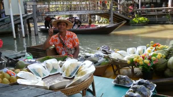 PATTAYA, TAILÂNDIA - 18 de dezembro de 2017: Vendedor de camisa colorida e chapéu de palha vende frutas tailandesas exóticas em um barco — Vídeo de Stock