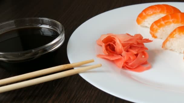 Négy nagy sushi darab lazac feküdj egy nagy lapos tányér. — Stock videók