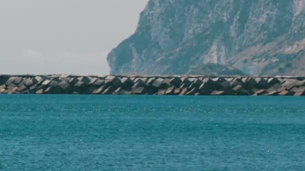 Sten-piren på Medelhavet, Gibraltar sund på en bakgrund av Gibraltarklippan och darrande av varmluft — Stockvideo