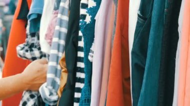 Şeyler askıda, el elbiselere bak ve seçin kadın asmak. Bit pazarı, piyasada satılan kıyafetleri