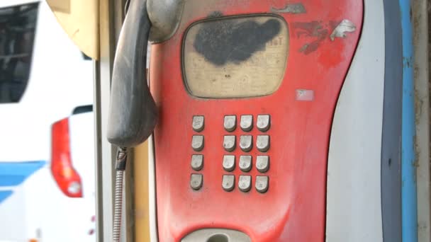 Gammal shabby röd telefon ligger på en stad gata. Vintage telefon i telefonkiosk — Stockvideo