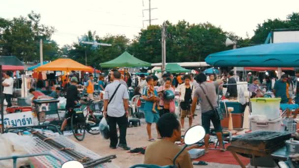 Паттайя - 16 грудня 2017: блошиний ринок в Таїланді. Люди вибирають речей на блошиному ринку. Багато речей б/у на поверсі — стокове відео