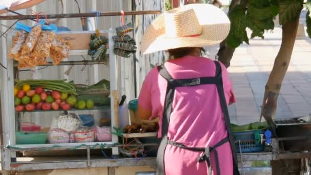 Donna tailandese vende street food tailandese su un carrello portatile. Asiatici piatti esotici — Video Stock