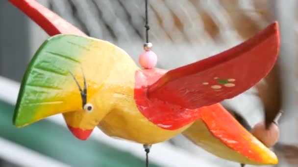 Escultura cinética de moinho de vento de madeira de pássaro colorido se desenvolve no vento — Vídeo de Stock