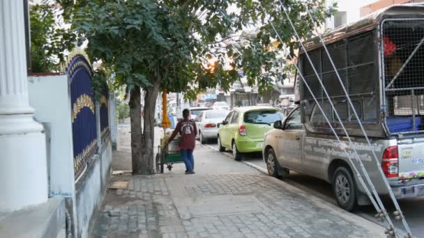Паттайя - 16 грудня 2017: Жінка продаж вуличної їжі, їзда на велосипеді кошик через дорогу повз обгоні — стокове відео