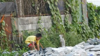 Pattaya, Tayland - 16 Aralık 2017: Toplamak bir yoksul dilenci çocuk tuğla ve taşlar şehrin sokaklarında