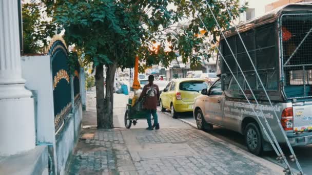 Pattaya, Tayland - 16 Aralık 2017: sokak gıda satış, arabalar geçerken geçmiş sokağın karşısındaki sepeti wheeling bir kadın — Stok video