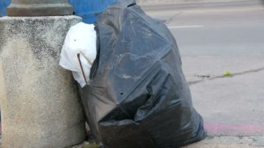 Sokakta geçen otomobil, motosiklet ve bisiklet ile büyük çöp torbaları artık yemek yiyecek ve atık dolu dolu çöp olduğunu