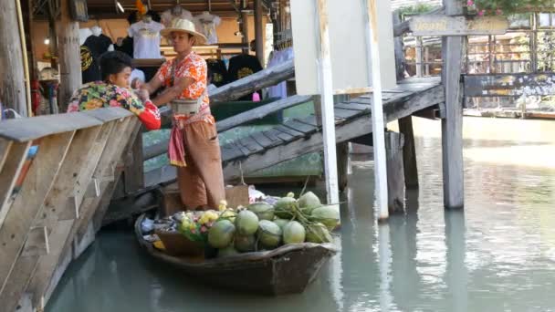 Pattaya, Thajsko - 18 prosince 2017: Prodávající v barevné tričko a slaměný klobouk prodává exotické thajské ovoce na lodi — Stock video