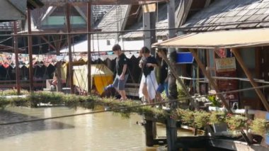 Pattaya, Tayland - 18 Aralık 2017: Kahverengi Nehri üzerinde duruyor romantik ahşap köprü yürüyüş turist, turizm tekneler Köprüsü'nün altında yelken