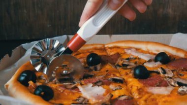 El siyah zeytinli pizza büyük İtalyan bir parça kesip, sosis, salam ve peynir kapat