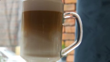 Kahve latte kaşıkla karıştırılır. Görünümü kadar yakın sütlü kahve karıştırma