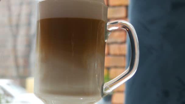 O café com leite é misturado com colher. Mistura de café com leite vista de perto — Vídeo de Stock
