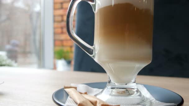 Koffie latte wordt gemengd met de lepel. Mengen van koffie met melk sluiten van weergave — Stockvideo