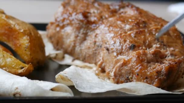 Heerlijk sappige stuk varkensvlees steak met aardappelen en groenten op een stijlvolle zwarte plaat in restaurant — Stockvideo