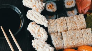 Suşi çeşitli ile ayarla büyük suşi rulo, maki, nigiri, gunkan şık koyu arka plan üzerinde. Soya sosu ve bambu çubuk yakındaki yalan