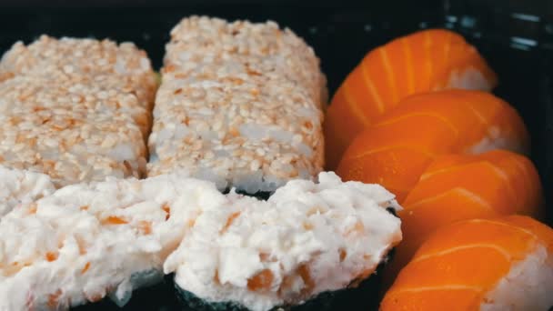 Kamera přesune vlevo od stylové čerstvé sushi set s různými druhy sushi rolls, zblízka — Stock video