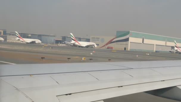 DUBAI, Emirati Arabi Uniti - 8 febbraio 2018: L'aereo in aeroporto si sta preparando per il decollo passando una moltitudine di altri velivoli diversi. Riprese dal salone — Video Stock
