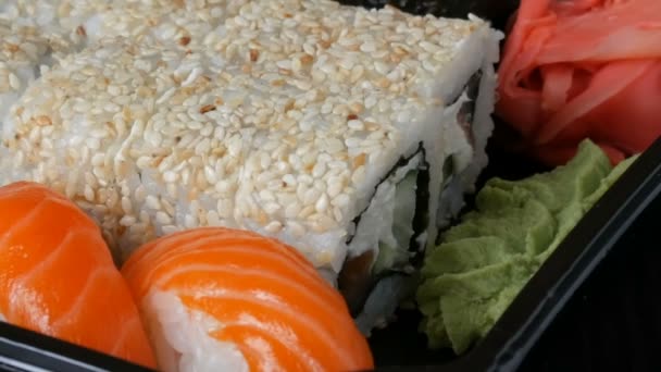 Камера удаляется от стильного свежего набора суши с различными видами рулонов суши, крупным планом — стоковое видео