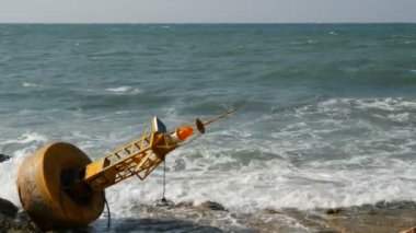 Masmavi deniz kıyısında büyük Sarı şamandıra. Dalgalar şamandıra vurmak