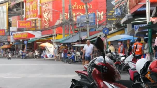 ПАТТАЯ, Таиланд - 7 февраля 2018 года: оживленная улица Таиланда со многими признаками красного цвета. Люди продают уличную еду. Проезжающие мимо мотоциклы и автомобили — стоковое видео