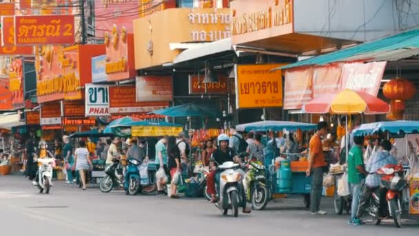 PATTAYA, TAILANDIA - 7 de febrero de 2018: Calle tailandesa animada con muchos signos de color rojo. La gente vende comida callejera. Motocicletas y coches que pasan — Vídeos de Stock