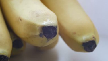 Bir salkım muzu sarı kabuğuna beyaz arka plan makro Görünümü Kapat