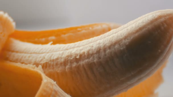 Жінка сексуально торкається пальцем очищеного банана, макро крупним планом — стокове відео