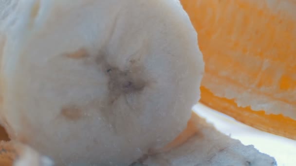 Cuerpo de plátano con la cáscara en un fondo blanco macro vista de cerca — Vídeos de Stock