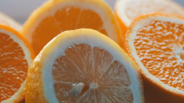 Cortar cítricos limón y naranja vista de cerca cerca sobre un fondo blanco — Vídeo de stock