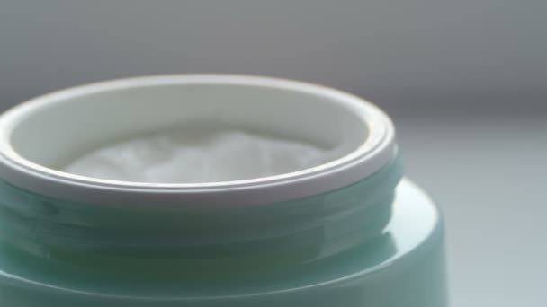 Green jar with the cosmetics gentle cream. Cosmetics cream macro close up view — Stock Video