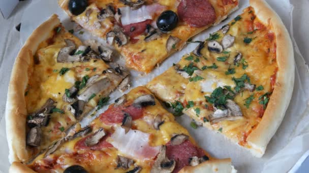 Muchos pedazos de la pizza con diferentes rellenos, aceitunas, pollo, champiñones, queso, tocino, salami, verduras. Pedazo de pizza se llevó y mordió — Vídeos de Stock