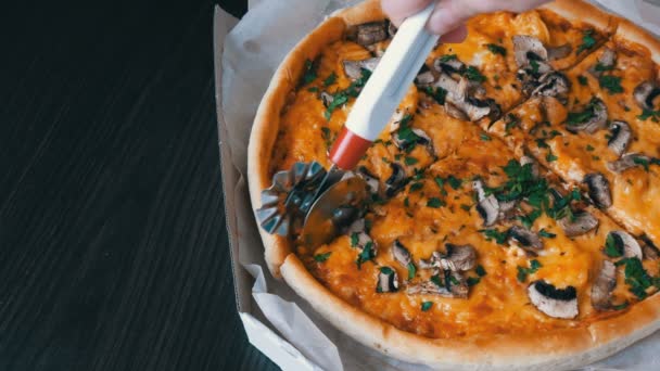 Pizza kniv nedskärningar runda pizza med med de gröna, kyckling, champinjoner och dubbel ost, på nära håll se — Stockvideo