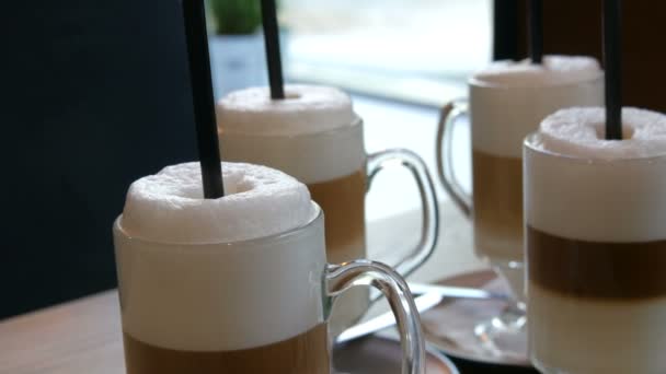 Mooie glazen met koffie latte en grote schuim in het café op de tafel — Stockvideo