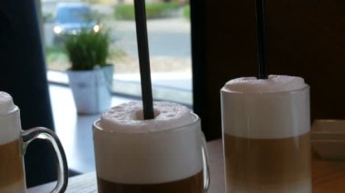 Güzel gözlük kahve latte ve masada kafede büyük köpük ile