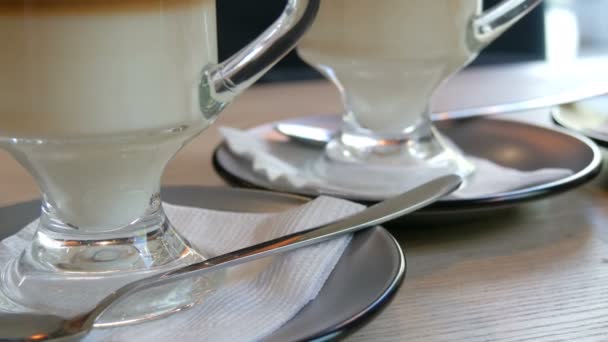 Количество стаканов с кофе латте стоять на блюдце на столе в кафе — стоковое видео